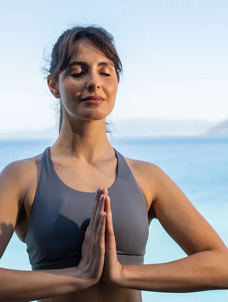 Donna in meditazione davanti al mare