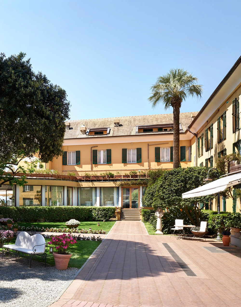Giardino e cortile dell'Hotel Cenobio dei Dogi con palme
