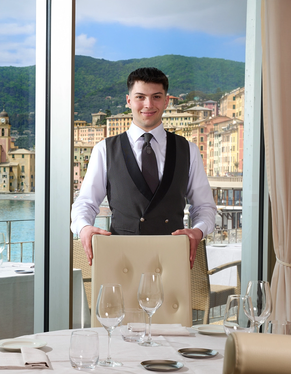 Cameriere del Ristorante Il Doge davanti alla vetrata sul mare