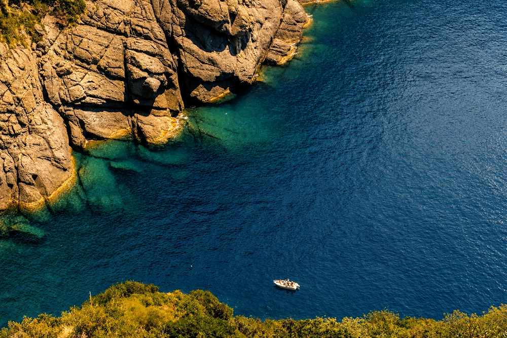 Barca in una baia tra le scogliere del Promontorio di Portofino