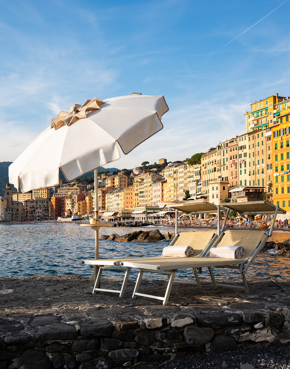 Lettini e ombrellone sulla spiaggia dell'hotel davanti al borgo di Camogli